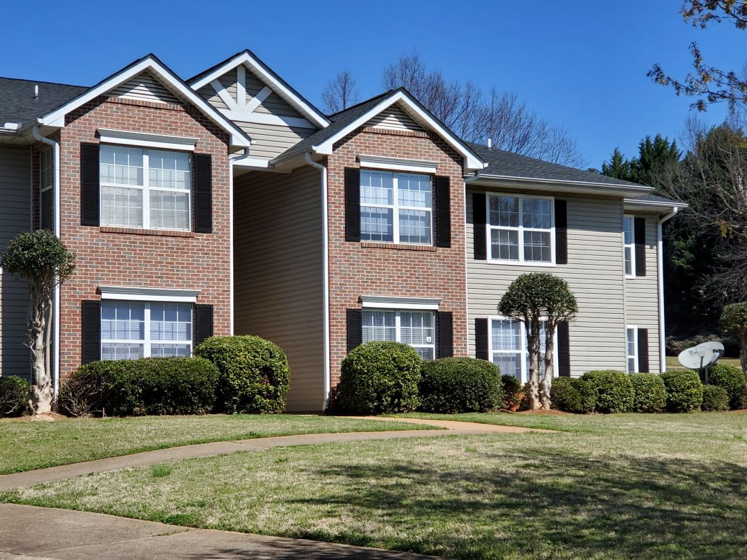 a large brick house with a sidewalk in front of it
